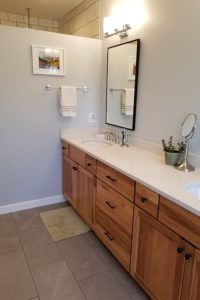 A master bath with two sinks and a large ceramic tub.