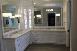 A master bathroom with chandelier lighting and an angled countertop.