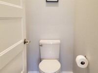 A small, half bath with a toilet.