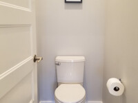 A small, half bath with a toilet.