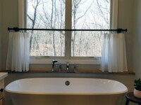 Stylish bathroom with vinyl floor and a large ceramic tub.