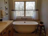 Stylish bathroom with vinyl floor and a large ceramic tub.