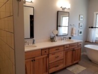 A master bath with two sinks and a large ceramic tub.