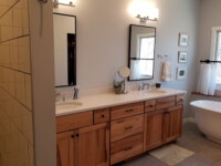 A master bath with two sinks and a large ceramic tub.