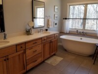Master bathroom with a tub and tile work