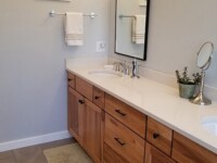 A master bath with two sinks and a large ceramic tub.