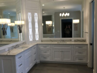 A master bathroom with chandelier lighting and an angled countertop.